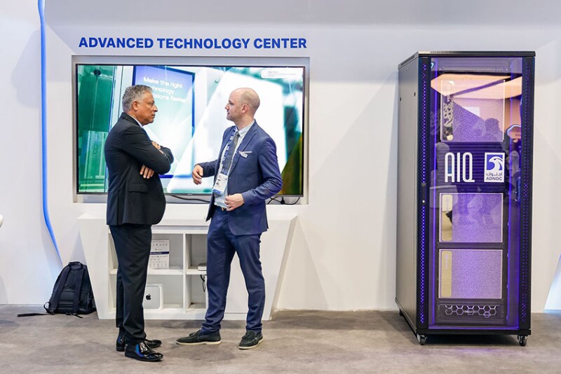 Conference participants converse next to the hottest new technology in the oil and gas industry, a server rack full of powerful chips that enable generative artificial intelligence. Source: ADIPEC.