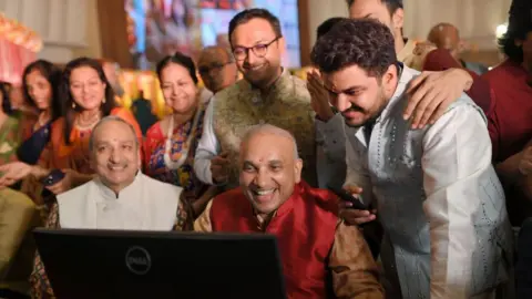 Getty Images A stock broker and his family watch a terminal during a special trading session for Diwali, the Hindu festival of lights, at the Bombay Stock Exchange (BSE) in Mumbai, India, on November 1, 2024.